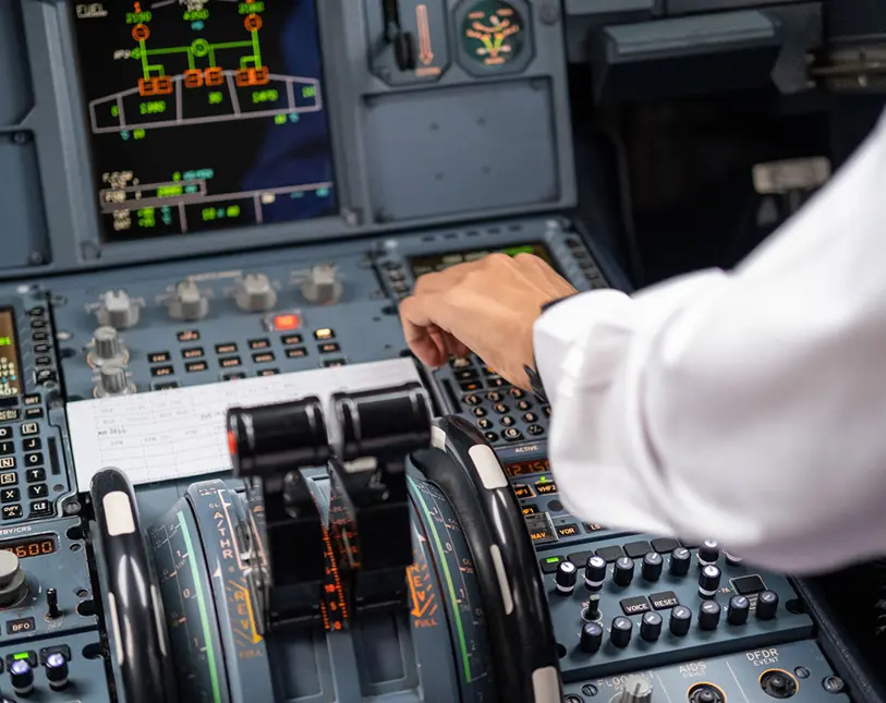 Pilot operating airplane cockpit controls and instruments.